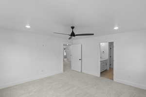 Unfurnished bedroom featuring light carpet, recessed lighting, connected bathroom, and ceiling fan