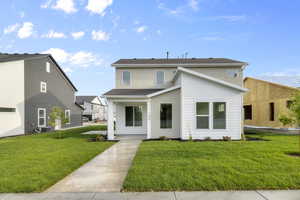 View of front of house featuring a front lawn and roof with shingles