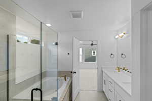 Bathroom with plenty of natural light, double vanity, a stall shower, and a bath
