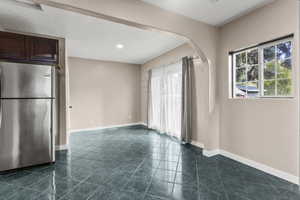 Unfurnished room with arched walkways and recessed lighting