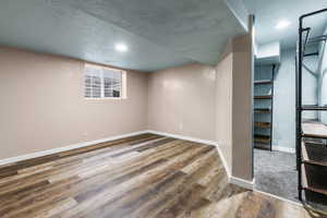 Below grade area with a textured ceiling, wood finished floors, and recessed lighting