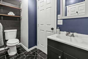 Half bath with vanity and a textured wall