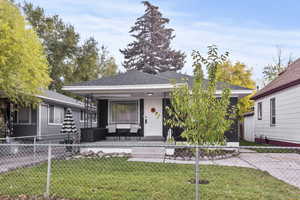 View of front facade with a fenced front yard and a shingled roof