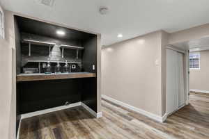 Bar area featuring wood finished floors and recessed lighting