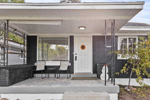 Property entrance with brick siding and a porch