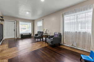 Living area with dark wood-type flooring and a textured ceiling