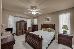 Bedroom with light carpet and a ceiling fan