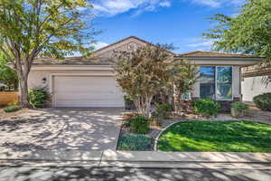 View of front of home featuring stucco siding, a tiled roof, concrete driveway, a garage, and a front yard