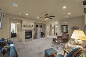 Carpeted living area featuring a tile fireplace, ceiling fan, recessed lighting, and healthy amount of natural light