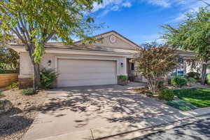 Ranch-style house featuring stucco siding, driveway, and a garage