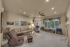 Living area featuring recessed lighting, carpet floors, ceiling fan, and a fireplace with flush hearth