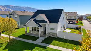 View of front facade featuring stone siding, a residential view, board and batten siding, covered porch, and a mountain view