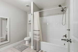 Bathroom with baseboards and shower / bathtub combination with curtain