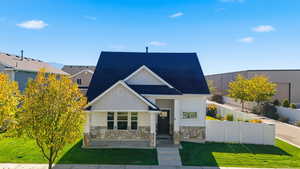 View of front facade featuring stone siding, board and batten siding, and a shingled roof