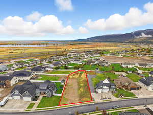 Aerial perspective of suburban area with property parcel outlined and mountains