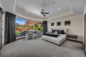 Bedroom featuring a raised ceiling, carpet flooring, a ceiling fan, and recessed lighting