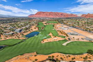View of property location featuring nearby suburban area, a local golf course, and a water and mountain view