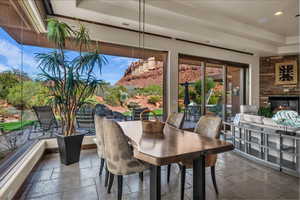 Dining space featuring stone tile flooring, a stone fireplace, and recessed lighting