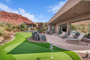 View of property's community with a putting area and a patio area