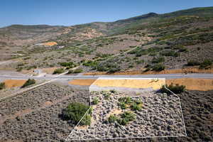 Overview of rural landscape featuring a mountainous background and property parcel outlined
