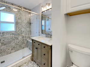 Full bath featuring vanity, a stall shower, and light tile patterned floors