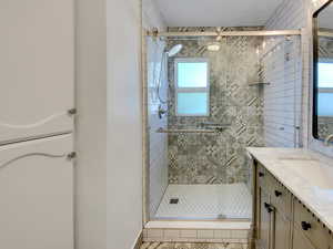 Bathroom featuring vanity, a shower stall, and light tile patterned floors