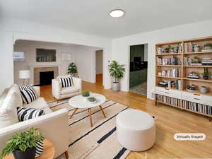 Living room with light wood-style flooring and a tile fireplace