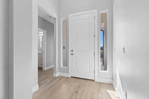 Foyer featuring light wood-style floors and baseboards