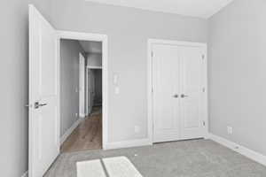 Unfurnished bedroom featuring light colored carpet and a closet