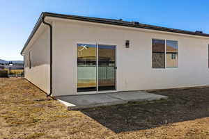 Back of property with stucco siding and a patio area