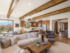 Living room with beamed ceiling, light wood finished floors, and recessed lighting
