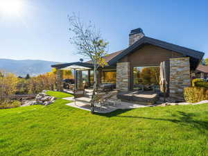 Back of property featuring a patio, a yard, and a chimney