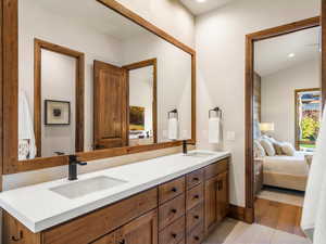 Bathroom with connected bathroom, double vanity, light wood-style flooring, and recessed lighting
