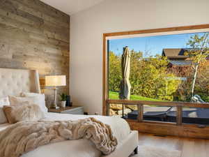 Bedroom with wood walls and hardwood / wood-style flooring