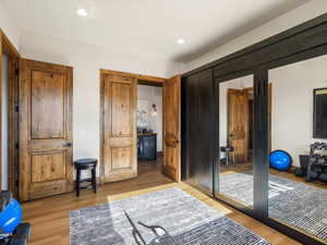 Bedroom with light wood finished floors, recessed lighting, and beverage cooler