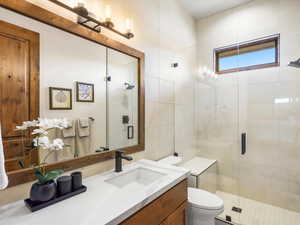 Full bathroom with vanity, a shower stall, and tile walls