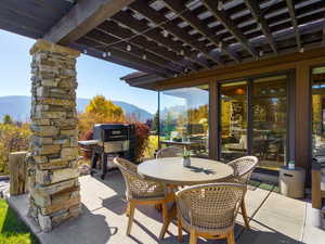 View of patio / terrace with a mountain view, outdoor dining space, and grilling area