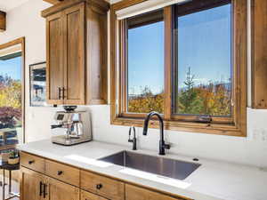 Kitchen with light stone counters and brown cabinetry