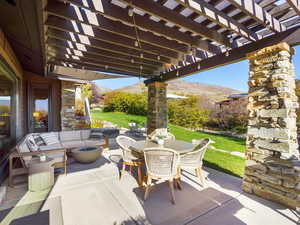 View of patio featuring a pergola, an outdoor living space with a fire pit, a mountain view, and outdoor dining space