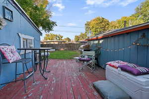 Wooden terrace with a fenced backyard and grilling area