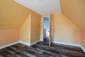 Bonus room featuring vaulted ceiling and dark wood-type flooring