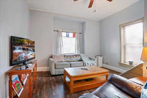 Living area featuring dark wood finished floors and ceiling fan