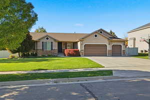 View of front of property featuring stone siding, stucco siding, concrete driveway, and a garage