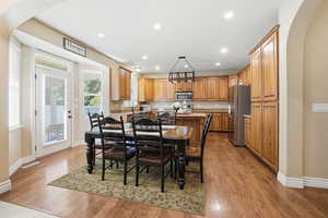 Dining space with arched walkways, recessed lighting, and dark wood-style floors