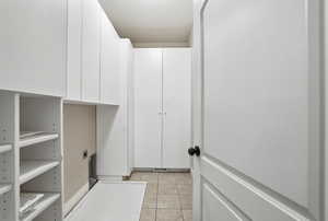 Washroom featuring light tile patterned floors and hookup for an electric dryer