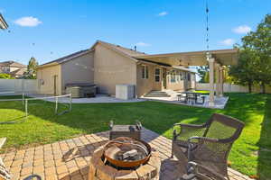 Rear view of property with a patio area, a fenced backyard, a hot tub, and stucco siding