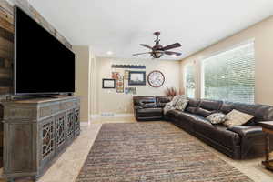 Living room with arched walkways, ceiling fan, and recessed lighting