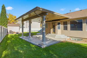 Rear view of house with a fenced backyard, a patio, ceiling fan, and stucco siding
