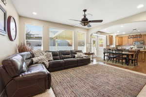 Living room featuring recessed lighting, arched walkways, a ceiling fan, and light wood-type flooring