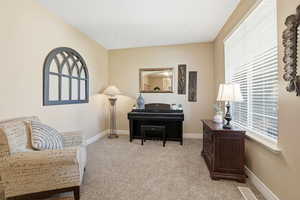 Sitting room featuring light carpet and baseboards